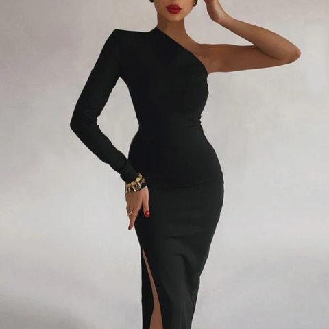 Woman wearing fitted black long-sleeve dress with side slit, one hand behind head, gold bracelet, red lipstick, posed