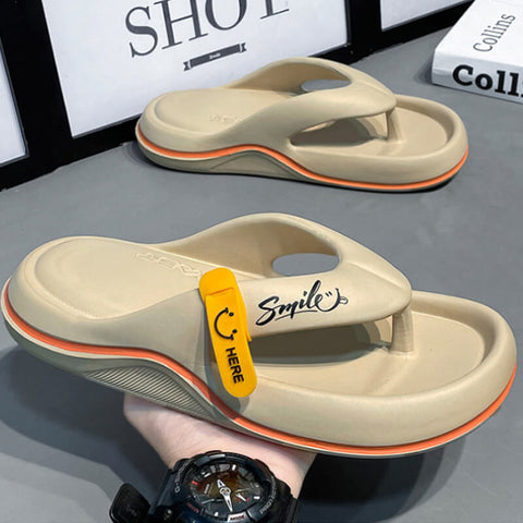 Cream-colored thong sandals with orange and coral striped soles, displayed on a hand wearing a black watch, with a second