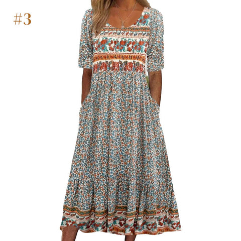Woman wearing a floral print midi dress with orange and white embroidered trim at neckline and waist, elbow-length sleeves