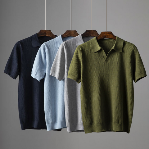 Four polo shirts hanging on wooden hangers against gray background. Colors from left to right: navy blue, light blue, gray
