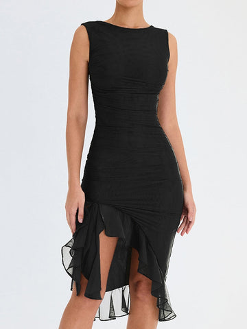 Person wearing sleeveless black dress with horizontal ruching across torso and asymmetrical ruffled mesh hem, against white