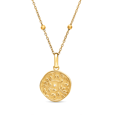 Gold pendant necklace with circular ornamental disc featuring leaf or floral detailing and small diamond accent, suspended