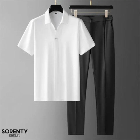 White short-sleeve collared shirt and black trousers displayed on hangers against gray background.