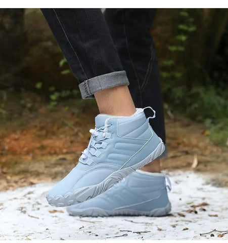 Person wearing light blue quilted high-top sneakers with white laces and soles, paired with dark rolled-cuff jeans, standing