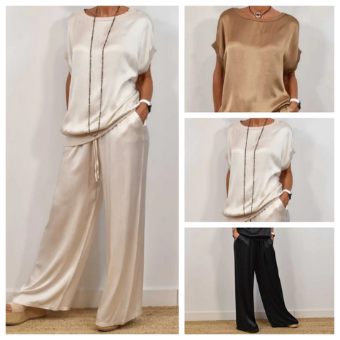 Woman wearing cream short-sleeved top with long beaded necklace and matching cream wide-leg pants, shown in full-length and