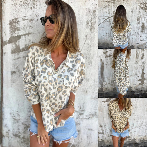 Woman wearing leopard print button-up shirt with sunglasses, posing against weathered white and gray wall with distressed