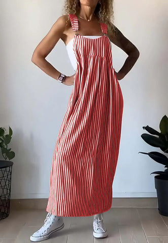 Woman wearing red and white vertical striped sleeveless maxi dress with adjustable shoulder straps, paired with white canvas